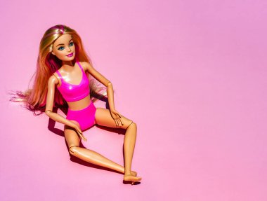 Güzel, Fransa - 29 Temmuz 2023 pembe arka planda pembe mayo ve aksesuar giyen sarışın bebek. Düz tabanlı modern Barbie. Yüksek kalite fotoğraf
