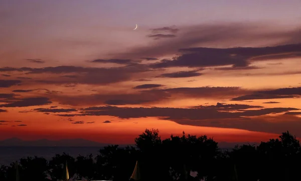 Czerwony Zachód Słońca Nad Morzem Klinem Księżyca Chmur Gór Tle — Zdjęcie stockowe