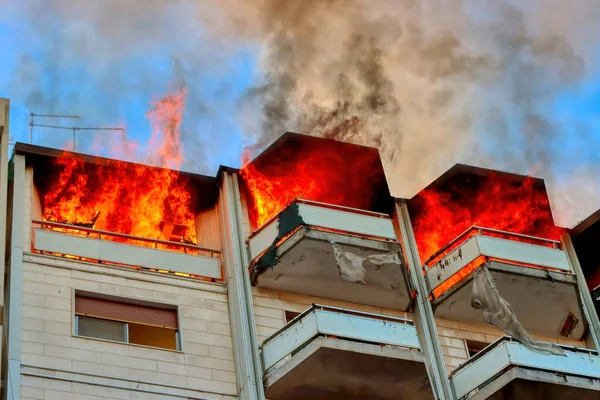 Fire in an attic of a building in an Italian city. Apartment on fire and flames. High quality photo