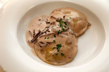 Panciotti stuffed with scamorza cheese and aubergines with radicchio and speck sauce. Italian pasta. Italian food. High quality photo