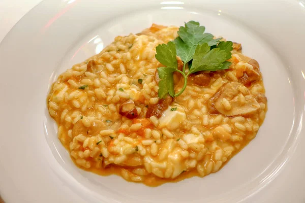 Risotto with pumpkin, porcini mushrooms and smoked scamorza cheese. Italian pasta. Italian food. High quality photo