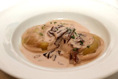Panciotti stuffed with scamorza cheese and aubergines with radicchio and speck sauce. Italian pasta. Italian food. High quality photo