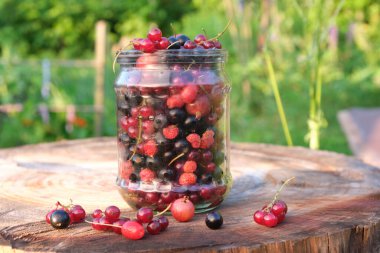 Tahta bir arka planda kavanozdaki çeşitli meyveler.