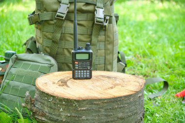 a walkie-talkie and a military tactical backpack. In nature
