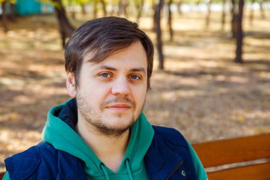 Güz Parkı 'ndaki veya ormandaki Avrupalı beyaz erkek adama bakıyorum. Vesikalık adam yaşam tarzı portresi.