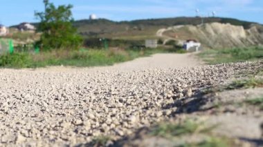 Genç bir erkek terlik, plaj terliği, turkuaz şort ve beyaz tişörtle dağda yürüyor. Yürüyüş. Odaklanmamış video
