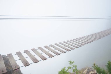 Derin siste turist asma köprüsü. Asılı ip köprü kayboluyor, ön manzara.