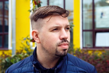 Male man with goatee beard on street. Head shot man lifestyle portrait close-up. Looking away, white caucasian businessman.