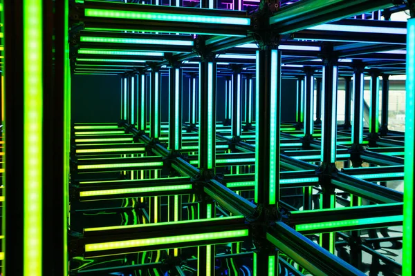 Futuristic green neon light cube art installation. Technology cyber cube