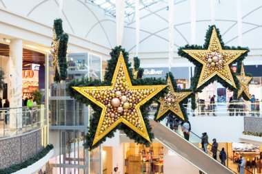 Büyük yıldızlar, alışveriş merkezinin iç kısımlarında yeni yıl dekorasyonu, yürüyen merdiven, cam çatı avlusu. Pavlodar, Kazakistan - 01.17.2023.