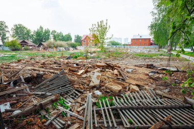 İnşaat atığı, çorak arazideki kırık ahşap çitler. Yıkılmış ev, harabeler, tarla, toprak yığını