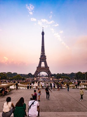 Paris, Fransa - Temmuz 2022: Günbatımında birçok turistle Eyfel Kulesi