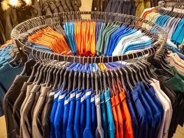 Tangerang, Endonezya - 15 Şubat 2025: Moda mağazasında renkli polo gömleklerle dolu dairesel asma askısı