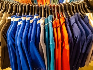 Tangerang, Endonezya - 15 Şubat 2025: Moda mağazasında renkli polo gömleklerle dolu dairesel asma askısı