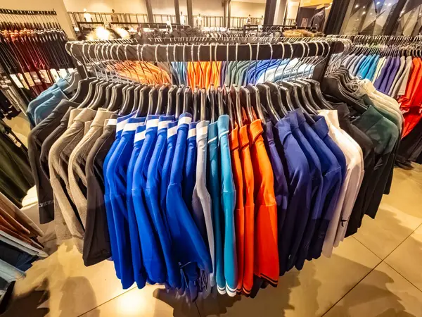 Tangerang, Endonezya - 15 Şubat 2025: Moda mağazasında renkli polo gömleklerle dolu dairesel asma askısı