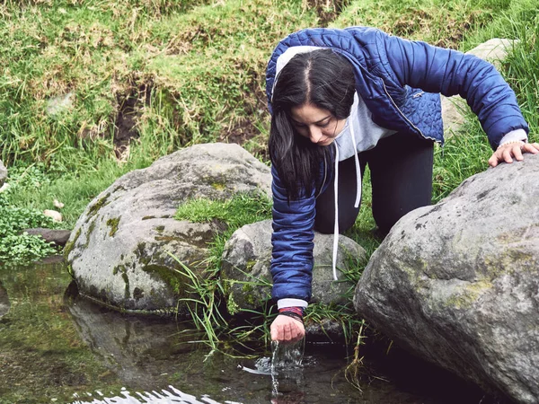 Embracing the Wild: Woman Hiking and Splashing Through a River, drink water