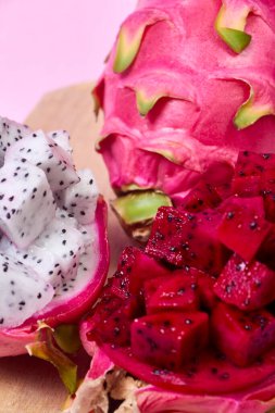 Kırmızı ejderha meyvesi seti. İştah açıcı. Pembe arka planda yalıtılmış. Üst manzara, el.