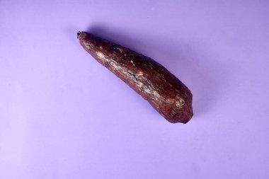 Taze Organik Cassava Kökü, Manioc Esculenta, yuca Mor arka planda, el masasında