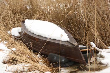 Kıyı kablosuz karında devrilmiş ahşap bir tekne.