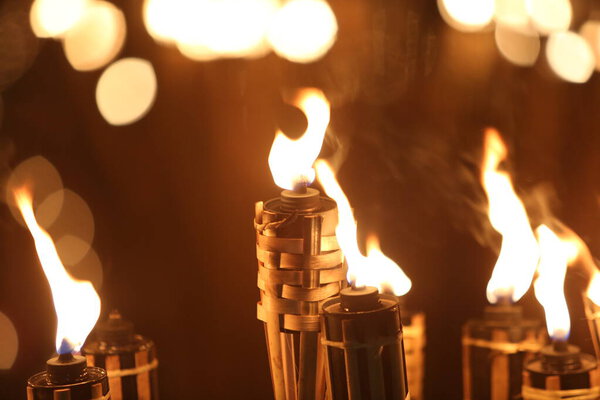 Факелы ночью с желтым пламенем и бликами