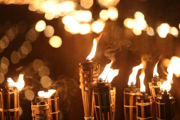 Факелы ночью с желтым пламенем и бликами