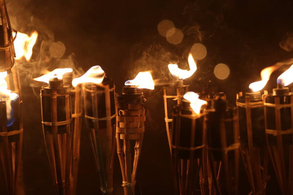 Факелы ночью с желтым пламенем и бликами