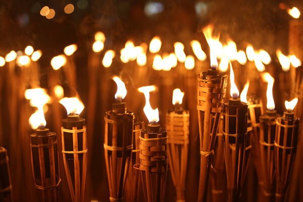 Факелы ночью с желтым пламенем и бликами