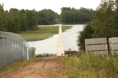 KRASLAVA DISTRICT, LATVIA - 8 AĞUSTOS 2023 Çit Letonya sınırında Belarus ile. Koruyucu altyapı