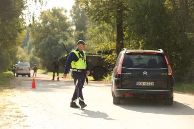 SILENE, LATVIA - 19 Eylül 2023: Kapsamlı Devlet Savunma Tatbikatı İsimleri 2023. Mobil kontrol noktasında takım çalışması koordinasyonu. Polis arabayı kontrol ediyor.