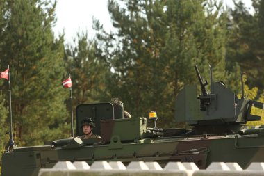 SILENE, LATVIA - 19 Eylül 2023: Kapsamlı Devlet Savunma Tatbikatı İsimleri 2023. Mobil kontrol noktasında takım çalışması koordinasyonu. Zırhlı araçtaki askerler.