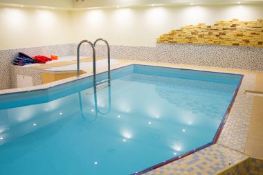 Paslanmaz çelik merdiveni olan kapalı yüzme havuzu