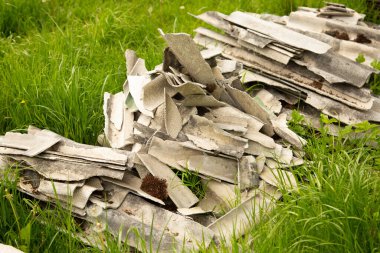 Çatıdan kayrak parçaları çimlerin üzerinde uzanıyor.