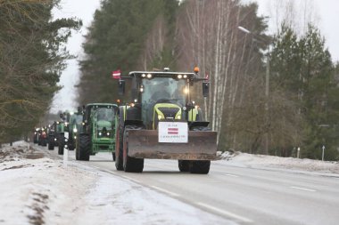 DAUGAVPILS, LATVIA - 5 Şubat 2024: Letonya 'da köylü protestosu. Traktörler, arabalar, tarım makineleri şehrin sokaklarında geziniyor.