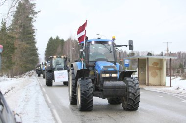 DAUGAVPILS, LATVIA - 5 Şubat 2024: Letonya 'da köylü protestosu. Traktörler, arabalar, tarım makineleri şehrin sokaklarında geziniyor.