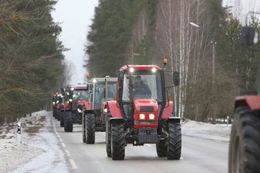 DAUGAVPILS, LATVIA - 5 Şubat 2024: Letonya 'da köylü protestosu. Traktörler, arabalar, tarım makineleri şehrin sokaklarında geziniyor.