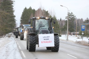 DAUGAVPILS, LATVIA - 5 Şubat 2024: Letonya 'da köylü protestosu. Traktörler, arabalar, tarım makineleri şehrin sokaklarında geziniyor.