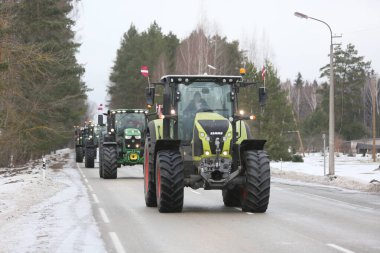 DAUGAVPILS, LATVIA - 5 Şubat 2024: Letonya 'da köylü protestosu. Traktörler, arabalar, tarım makineleri şehrin sokaklarında geziniyor.