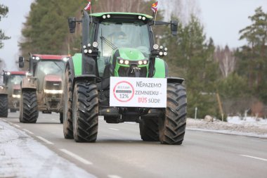 DAUGAVPILS, LATVIA - 5 Şubat 2024: Letonya 'da köylü protestosu. Traktörler, arabalar, tarım makineleri şehrin sokaklarında geziniyor.