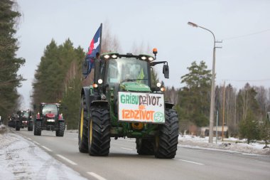 DAUGAVPILS, LATVIA - 5 Şubat 2024: Letonya 'da köylü protestosu. Traktörler, arabalar, tarım makineleri şehrin sokaklarında geziniyor.