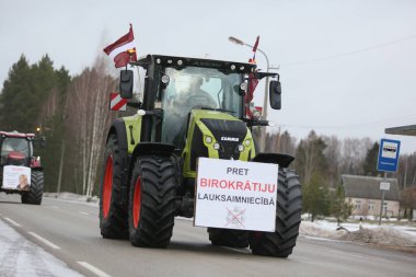 DAUGAVPILS, LATVIA - 5 Şubat 2024: Letonya 'da köylü protestosu. Traktörler, arabalar, tarım makineleri şehrin sokaklarında geziniyor.