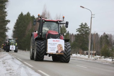 DAUGAVPILS, LATVIA - 5 Şubat 2024: Letonya 'da köylü protestosu. Traktörler, arabalar, tarım makineleri şehrin sokaklarında geziniyor.