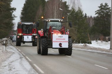 DAUGAVPILS, LATVIA - 5 Şubat 2024: Letonya 'da köylü protestosu. Traktörler, arabalar, tarım makineleri şehrin sokaklarında geziniyor.