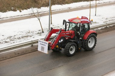 DAUGAVPILS, LATVIA - 5 Şubat 2024: Letonya 'da köylü protestosu. Traktörler, arabalar, tarım makineleri şehrin sokaklarında geziniyor.