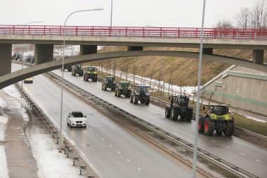DAUGAVPILS, LATVIA - 5 Şubat 2024: Letonya 'da köylü protestosu. Traktörler, arabalar, tarım makineleri şehrin sokaklarında geziniyor.