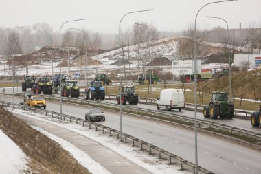 DAUGAVPILS, LATVIA - 5 Şubat 2024: Letonya 'da köylü protestosu. Traktörler, arabalar, tarım makineleri şehrin sokaklarında geziniyor.