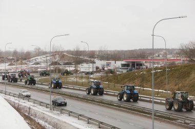DAUGAVPILS, LATVIA - 5 Şubat 2024: Letonya 'da köylü protestosu. Traktörler, arabalar, tarım makineleri şehrin sokaklarında geziniyor.