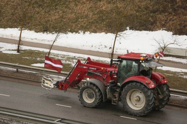 DAUGAVPILS, LATVIA - 5 Şubat 2024: Letonya 'da köylü protestosu. Traktörler, arabalar, tarım makineleri şehrin sokaklarında geziniyor.