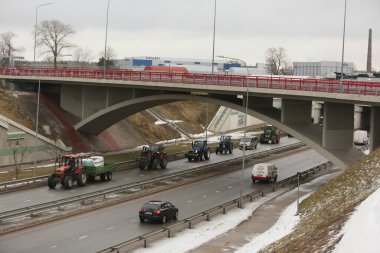 DAUGAVPILS, LATVIA - 5 Şubat 2024: Letonya 'da köylü protestosu. Traktörler, arabalar, tarım makineleri şehrin sokaklarında geziniyor.
