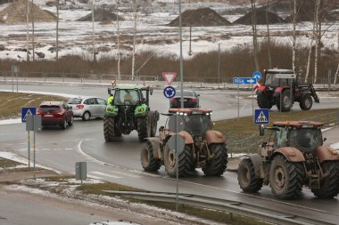 DAUGAVPILS, LATVIA - 5 Şubat 2024: Letonya 'da köylü protestosu. Traktörler, arabalar, tarım makineleri şehrin sokaklarında geziniyor.