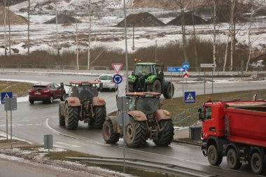 DAUGAVPILS, LATVIA - 5 Şubat 2024: Letonya 'da köylü protestosu. Traktörler, arabalar, tarım makineleri şehrin sokaklarında geziniyor.